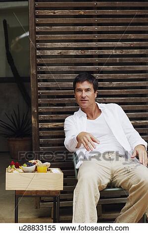 Portrait of a mature man reclining on a chair View Large Photo Image Stock Photography - Portrait of a mature man reclining on a chair. Fotosearch