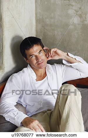Stock Photo - Portrait of a mature man reclining on the bed. Fotosearch