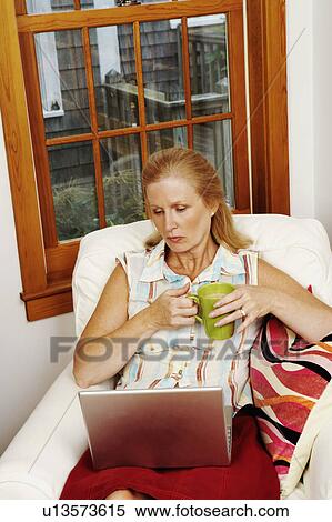 Mature woman looking at a laptop View Large Photo Image Stock Photography - Mature woman looking at a laptop. Fotosearch