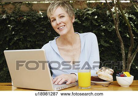 Stock Photo - Portrait of a mature woman working on a laptop. Fotosearch