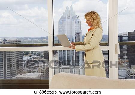 Stock Photography - Side profile of a businesswoman using a laptop. Fotosearch