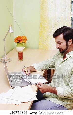 Side profile of a mature man sitting in front of a laptop and holding a document View Large Photo Image Stock Image - Side profile of a mature man sitting in front of a laptop and holding a document. Fotosearch
