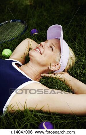 Mature woman lying on the grass and smiling View Large Photo Image Stock Photograph - Mature woman lying on the grass and smiling. Fotosearch