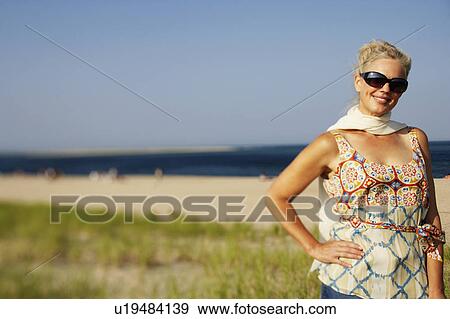 Mature woman standing on the beach and smiling View Large Photo Image Stock Photo - Mature woman standing on the beach and smiling. Fotosearch