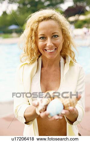Portrait of a mature woman holding conch shells View Large Photo Image Stock Photo - Portrait of a mature woman holding conch shells. Fotosearch