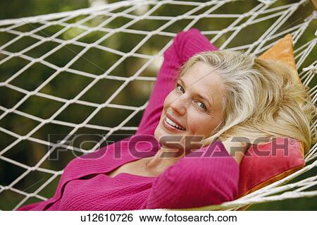 Portrait of a mature woman lying in a hammock and smiling View Large Photo Image Stock Photograph - Portrait of a mature woman lying in a hammock and smiling. Fotosearch
