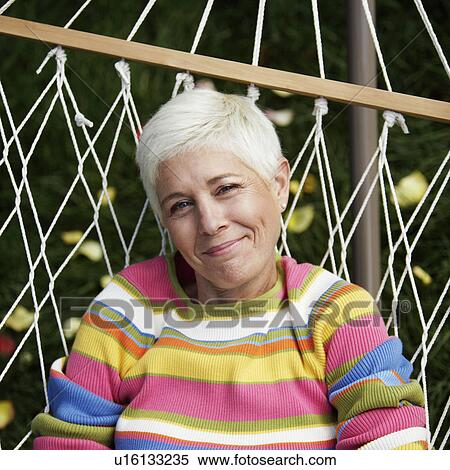 Stock Photography - Portrait of a mature woman lying in a hammock. Fotosearch