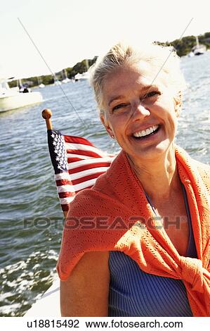 Stock Image - Portrait of a mature woman smiling in a boat. Fotosearch