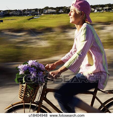 Side profile of a mature woman riding a bicycle View Large Photo Image Stock Photo - Side profile of a mature woman riding a bicycle. Fotosearch