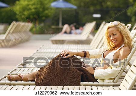Side profile of a mature woman reclining on a lounge chair View Large Photo Image Stock Image - Side profile of a mature woman reclining on a lounge chair. Fotosearch