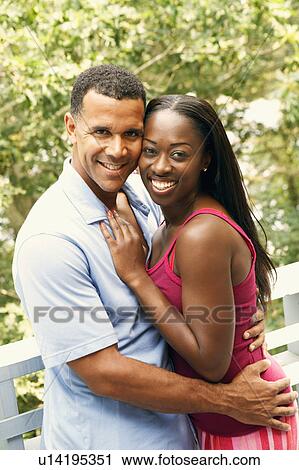 Portrait of a mature man embracing a mid adult woman and smiling View Large Photo Image Stock Image - Portrait of a mature man embracing a mid adult woman and smiling. Fotosearch