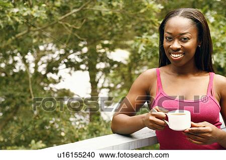 Portrait of a mid adult woman holding a cup of tea and smiling View Large Photo Image Stock Image - Portrait of a mid adult woman holding a cup of tea and smiling. Fotosearch