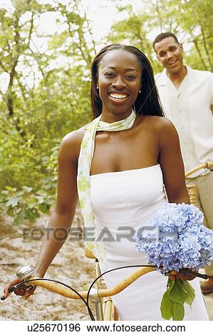 Portrait of a mid adult woman smiling with a mature man standing behind her View Large Photo Image Stock Photograph - Portrait of a mid adult woman smiling with a mature man standing behind her. Fotosearch