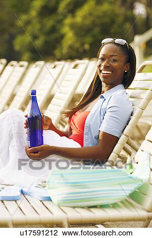 Side profile of a mid adult woman reclining on a lounge chair View Large Photo Image Stock Image - Side profile of a mid adult woman reclining on a lounge chair. Fotosearch