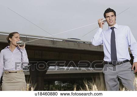 Business team talking through tin cans View Large Photo Image Stock Image - Business team talking through tin cans. Fotosearch