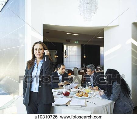 Stock Photograph - Businesswoman on phone during meeting. Fotosearch