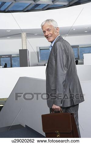Stock Image - Mature businessman on stairs. Fotosearch