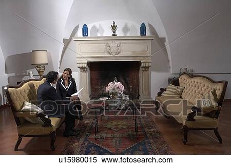 Stock Photography - Mature couple reading documents in living room. Fotosearch
