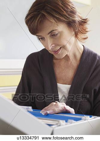Senior woman looking through files View Large Photo Image Stock Image - Senior woman looking through files. Fotosearch