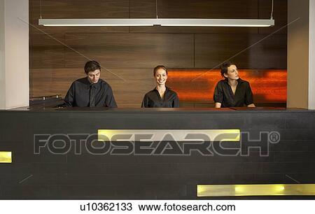 Staff at reception in hotel lobby View Large Photo Image Stock Image - Staff at reception in hotel lobby. Fotosearch