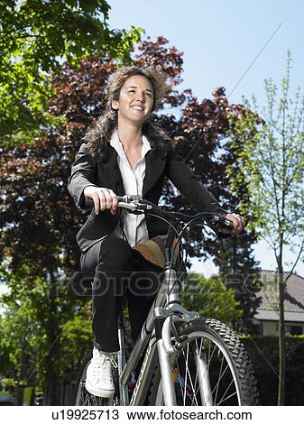 Stock Image - Woman riding her bicycle. Fotosearch