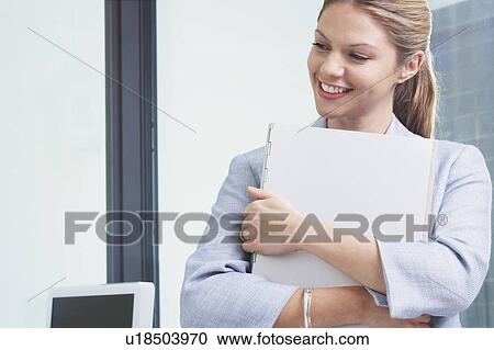 Young Business woman in office with file smiling. View Large Photo Image Stock Image - Young Business woman in office with file smiling.. Fotosearch