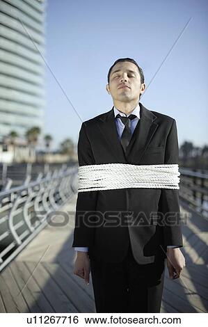 Business man tied up with ropes outdoors View Large Photo Image Stock Photograph - Business man tied up with ropes outdoors. Fotosearch