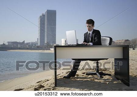 Stock Image - Business woman in beachfront office. Fotosearch