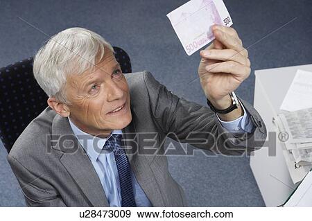 Businessman checking a 500 euro note View Large Photo Image Stock Photo - Businessman checking a 500 euro note. Fotosearch