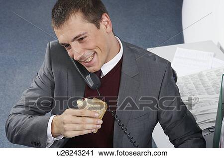 Stock Image - Businessman on phone, smiling. Fotosearch