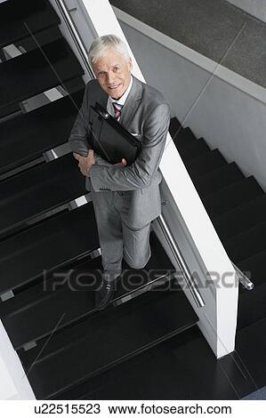 Stock Image - Businessman standing on stairs. Fotosearch
