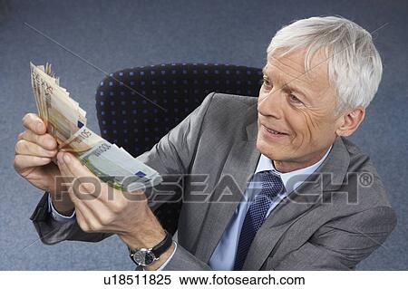 Stock Photography - Businessman with lots of money in hands. Fotosearch