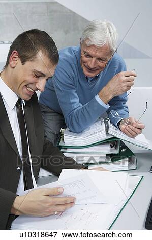 Stock Photo - Colleagues looking at document. Fotosearch