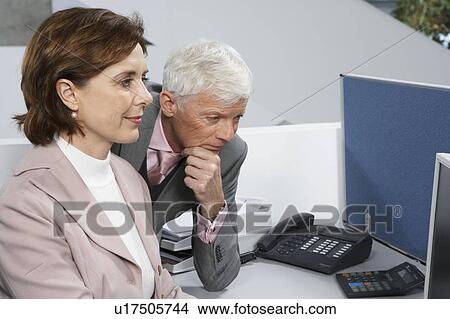 Colleagues looking into computer View Large Photo Image Picture - Colleagues looking into computer. Fotosearch