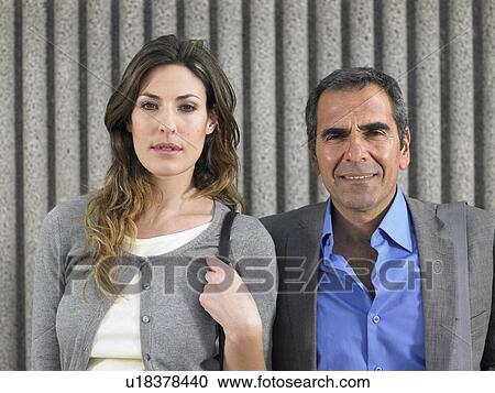 Head and shoulders portrait of older man and young woman in business suits looking into camera against textured concrete, Alicante, Spain, View Large Photo Image Stock Image - Head and shoulders portrait of older man and young woman in business suits looking into camera against textured concrete, Alicante, Spain,. Fotosearch