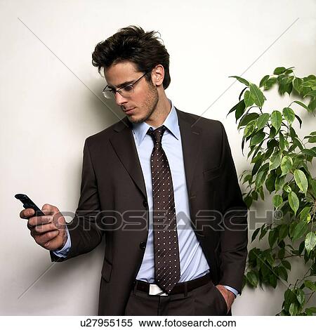 Stock Photography - Man holding phone in office. Fotosearch