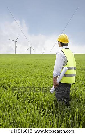 Man holding plans on a wind farm View Large Photo Image Stock Photo - Man holding plans on a wind farm. Fotosearch