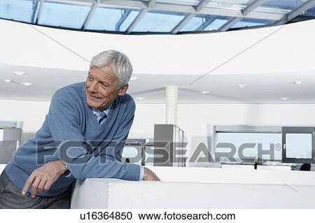 Stock Image - Man leaning against balustrade. Fotosearch