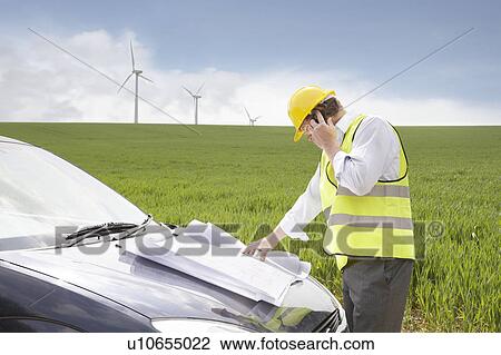 Stock Image - Man on mobile on a wind farm. Fotosearch