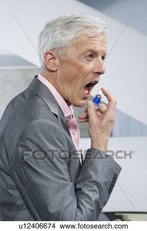 Man using mouthspray View Large Photo Image Picture - Man using mouthspray. Fotosearch