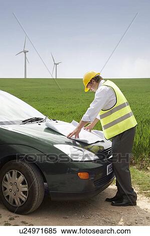 Man with plans on a wind farm View Large Photo Image Stock Photography - Man with plans on a wind farm. Fotosearch