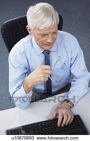 Stock Image - Mature businessman at desk. Fotosearch