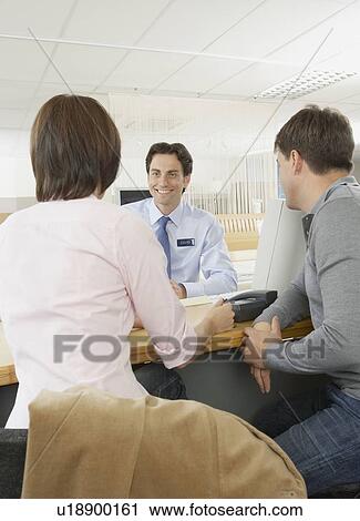 Salesman talking to couple in a shop. View Large Photo Image Stock Image - Salesman talking to couple in a shop.. Fotosearch
