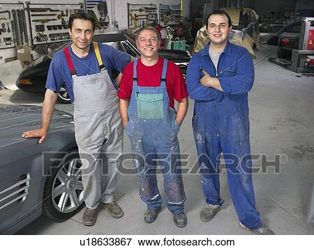 Three workers in a garage. View Large Photo Image Stock Photo - Three workers in a garage.. Fotosearch