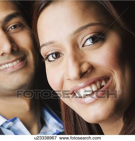 Stock Photo - Close-up of a young couple smiling. Fotosearch