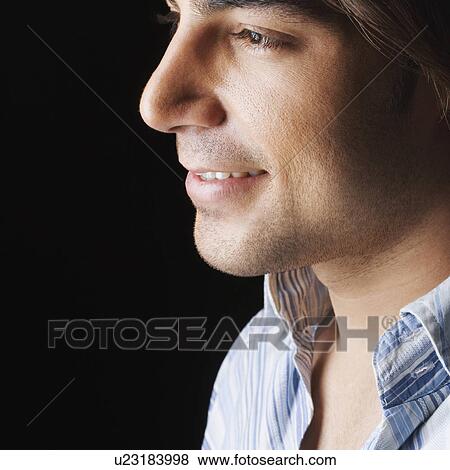 Close-up of a young man smiling View Large Photo Image Stock Photo - Close-up of a young man smiling. Fotosearch