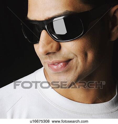 Close-up of a young man wearing sunglasses View Large Photo Image Stock Photo - Close-up of a young man wearing sunglasses. Fotosearch