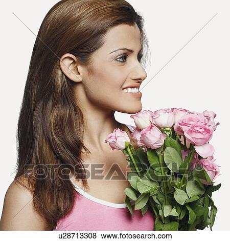Stock Photo - Close-up of a young woman holding a bouquet of flowers. Fotosearch