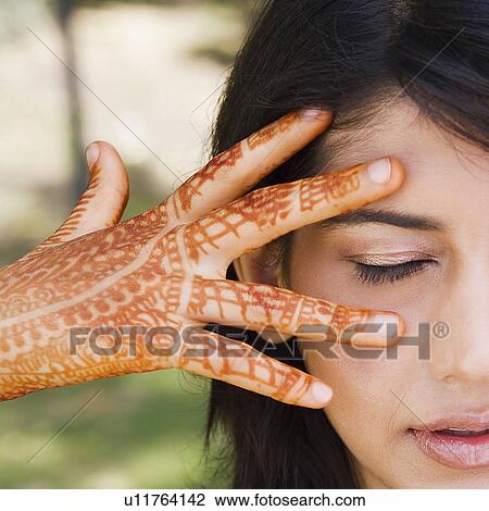 Stock Image - Close-up of a young woman showing her henna tattooed hand. Fotosearch