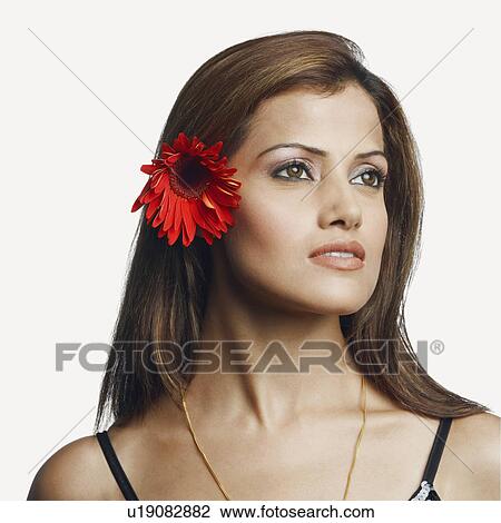 Stock Image - Close-up of a young woman wearing a flower. Fotosearch